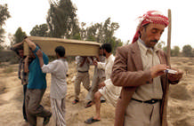 A gravedigger took pause for a cigarette outside the Abu Ghraib jail near Baghdad